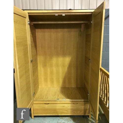 1498 - Ercol Furniture - A light oak Bosco range wardrobe, fitted with double doors above a drawer to the b... 