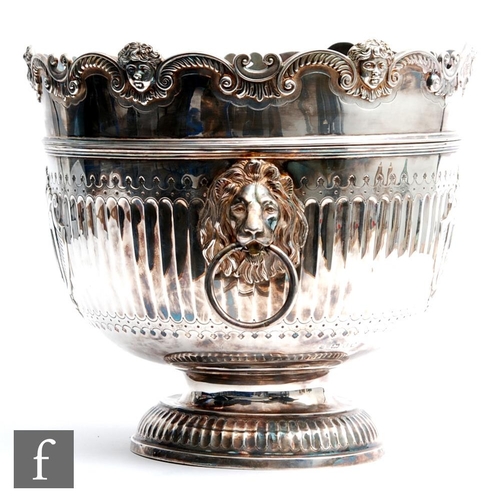 100 - A hallmarked silver twin handled punch bowl with fluted foot and body flanked by lion masked ring ha... 