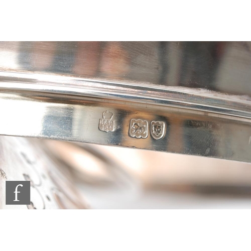 100 - A hallmarked silver twin handled punch bowl with fluted foot and body flanked by lion masked ring ha... 