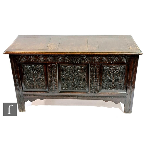 1150 - A late 17th Century to early 18th Century oak coffer, with triple fielded panel front carved with fo... 