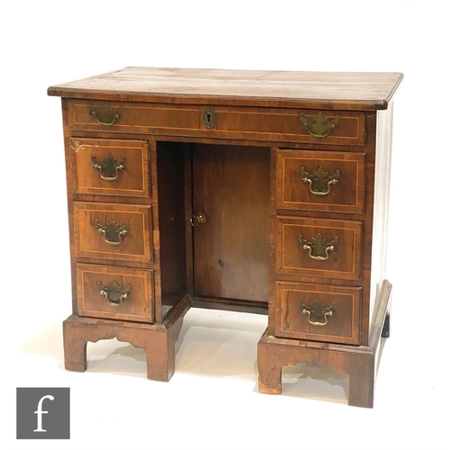 1165 - A George III line inlaid walnut veneered and pine kneehole writing desk, fitted with an arrangement ... 