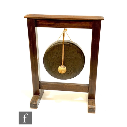 1138 - A 1930s oak framed brass gong and stand with beater, on trestle base, width 66cm.