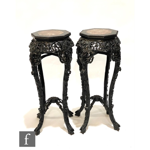 1142 - A pair of late 19th Century carved octagonal hardwood jardinière stands each with a veined rouge mar... 