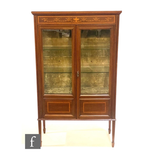 1146 - An Edwardian satinwood cross-banded and inlaid display cabinet enclosed by a pair of doors below a f... 