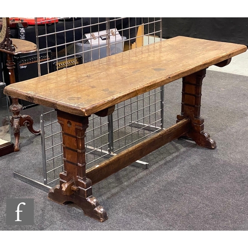 1136 - A 20th Century oak refectory table, the rectangular top above carved trestle ends united by a single... 