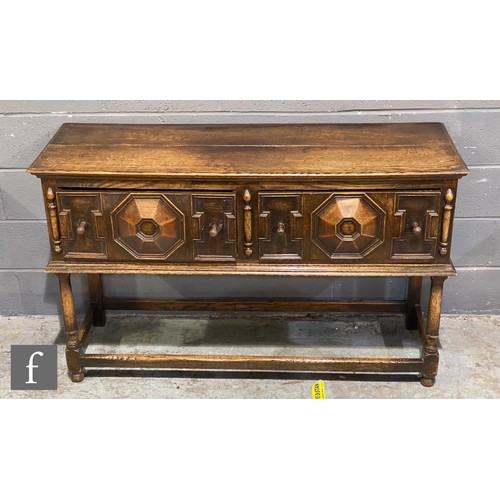 1137 - A 17th Century style oak dresser base, the plank top over a projecting geometric moulded front, turn... 