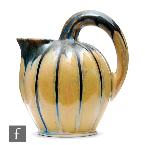 22 - Lacourbas - An early 20th Century French Art Nouveau jug formed as a melon with high loop handle and... 