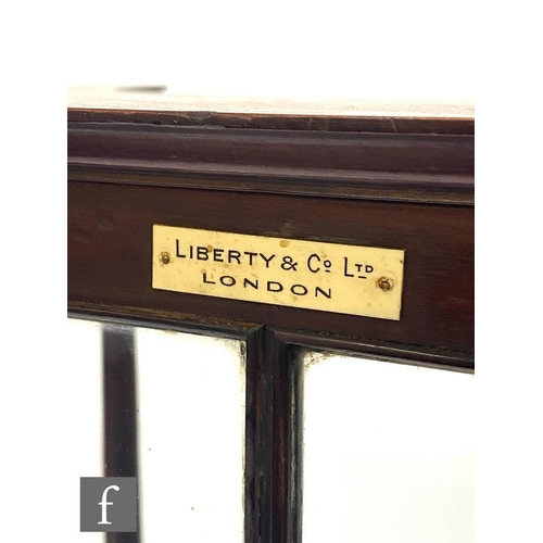 48 - Liberty & Co - A mahogany writing cabinet, the canopy top over a sectional glazed panel and a fa... 