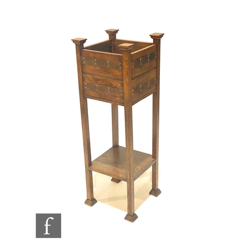 39 - In the manner of Shapland & Petter - An oak jardinière stand of square form, with riveted copper... 