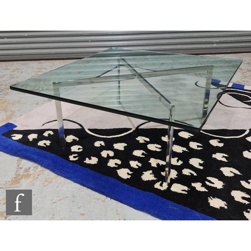 1244 - After Ludwig Mies Van Der Rohe - A glass top coffee table with chromium plated flattened steel X-fra... 