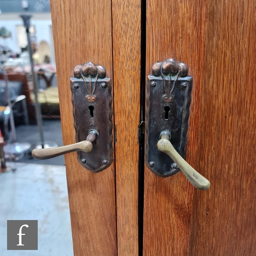 50 - Unknown - An oak wardrobe, the cornice pediment above double doors with a mirror panel and repousse ... 