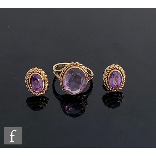 549 - A 9ct hallmarked single stone amethyst ring, oval collar set stone within a rope twist border, with ... 