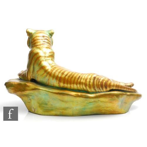 129 - A large Zsolnay eosin glaze model of a tiger reclining on a rock, inscribed Tigus regalis to the fro... 