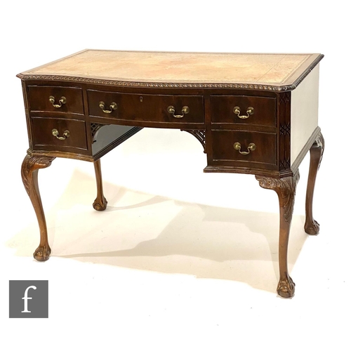 1233 - An Edwardian mahogany serpentine Chippendale style kneehole desk, fitted with five drawers below a g... 