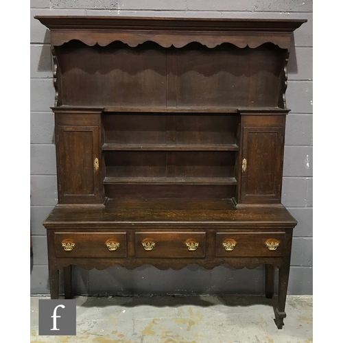 1234 - An early 20th Century oak dresser in the Georgian style, the upright section with shaped cornice fri... 