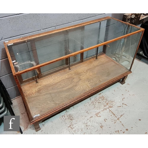 1229 - An early 20th Century oak framed shop display cabinet, the counter top fixed with an Imperial brass ... 