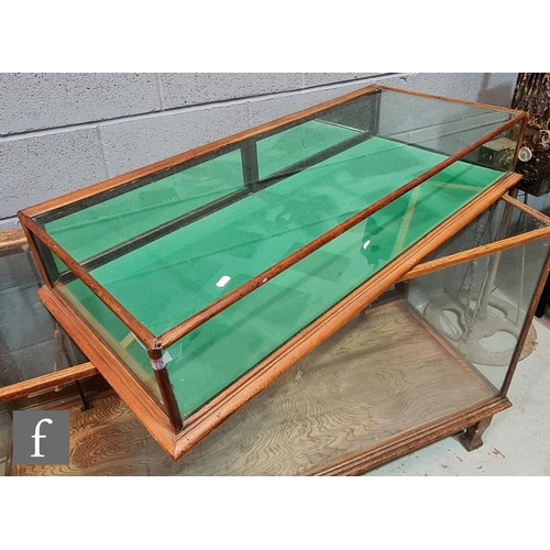 1231 - A 19th Century mahogany flat top glazed display cabinet with green baize lining and two back drop do... 