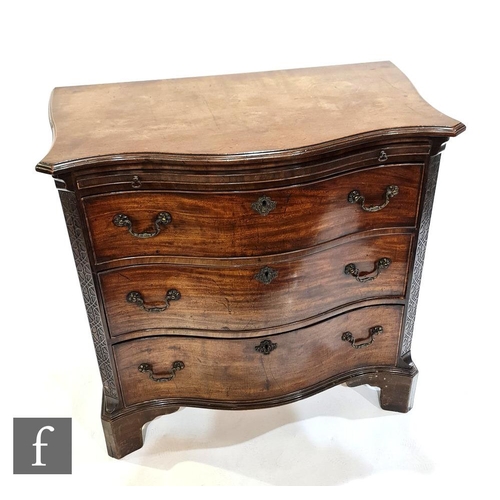 1243 - A George III style mahogany serpentine chest of three long drawers below a leather inset brushing sl... 