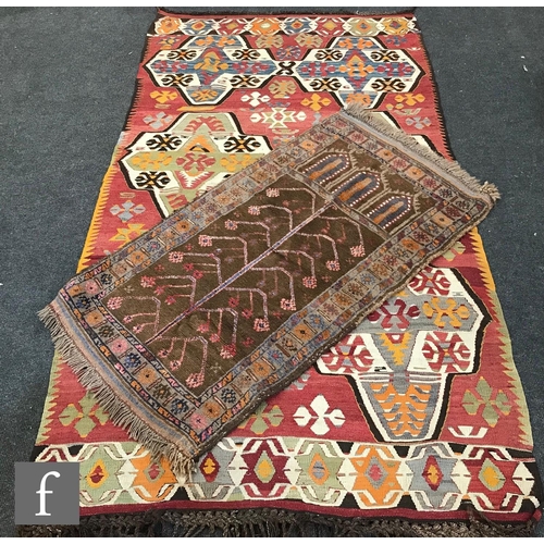 1235 - Two Turkish kilim rugs, the first a Mut example on a red coloured ground, 233cm x 124cm, and the sec... 