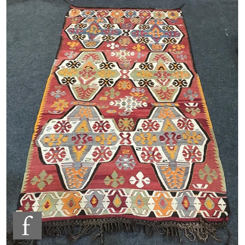 1235 - Two Turkish kilim rugs, the first a Mut example on a red coloured ground, 233cm x 124cm, and the sec... 