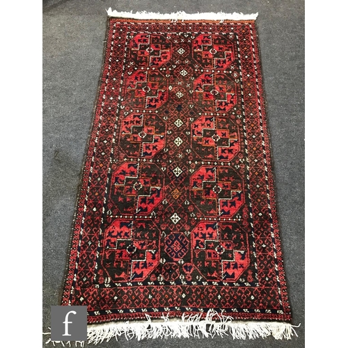 1238 - Two mid 20th Century Middle Eastern rugs, each decorated with ten medallions on a red ground within ... 