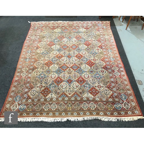 1240 - A 1960s Persian Koum or Kum carpet of red, salmon pink, blue and oatmeal colours, the central diamon... 