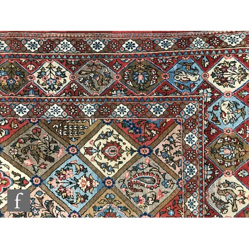 1240 - A 1960s Persian Koum or Kum carpet of red, salmon pink, blue and oatmeal colours, the central diamon... 