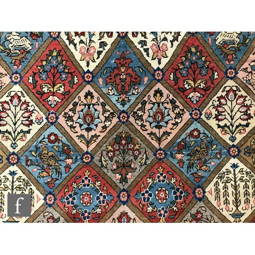 1240 - A 1960s Persian Koum or Kum carpet of red, salmon pink, blue and oatmeal colours, the central diamon... 