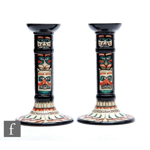 12 - A pair of Moorcroft Pottery Collectors Club totem pole candlesticks decorated with tubelined motif w... 