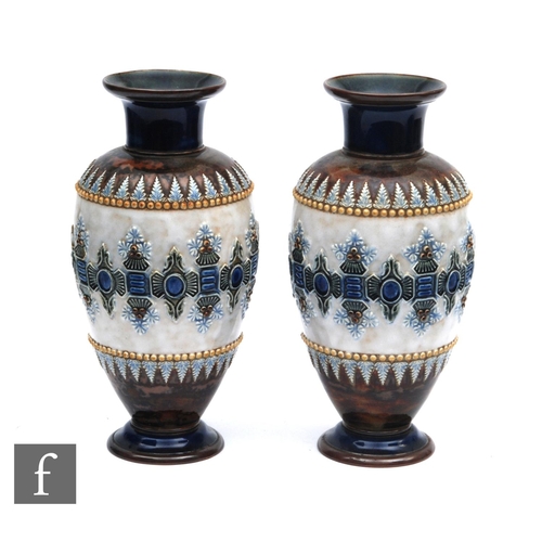 137 - A pair of late 19th Century Doulton Lambeth vases decorated with a central raised panel with stiff l... 