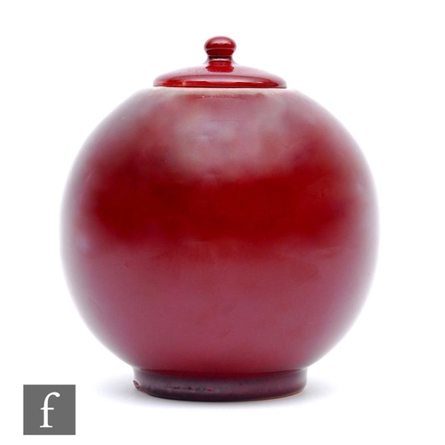 20 - A later 20th Century spherical jar and cover decorated in an all over oxblood flambe red, in the man... 