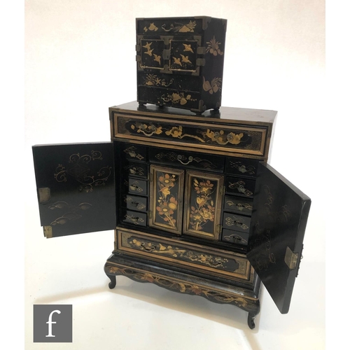 192 - A late 19th Century Japanese black chinoiserie lacquered table cabinet on stand, the centre section ... 