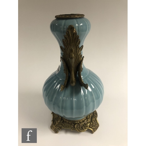 194 - A Chinese Robin's Egg blue porcelain vase of bottle form, rising to a garlic head, applied with reli... 