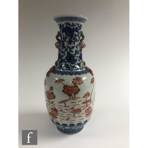 212 - A Chinese blue and white porcelain vase of bottle form applied with iron-red enamels to the central ... 