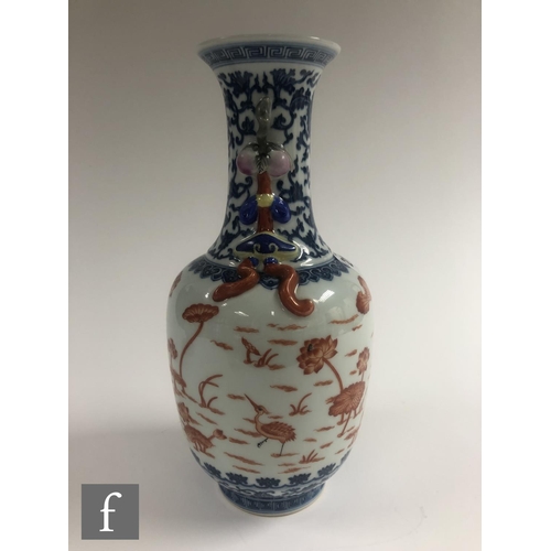 212 - A Chinese blue and white porcelain vase of bottle form applied with iron-red enamels to the central ... 