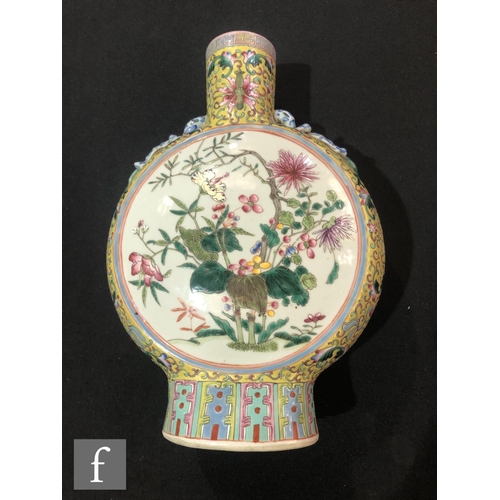 202 - A Chinese yellow ground famille rose moonflask, the porcelain flask rising from a high foot and flan... 