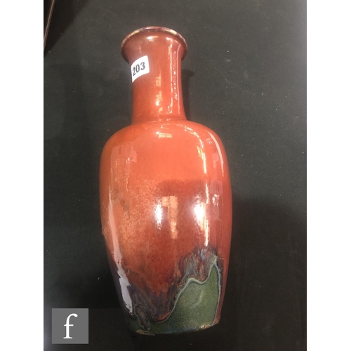 203 - A Chinese flambe glazed bottle vase, the purple and mauve glazes swirling at the base and rising to ... 