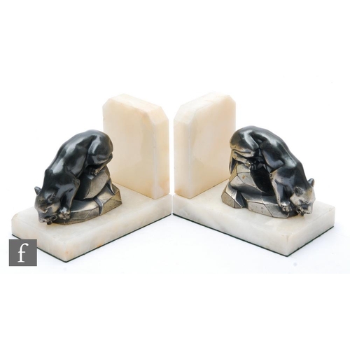 904 - A pair of 20th Century Art Deco bookends, decorated with silvered spelter stylised panthers on rocky... 