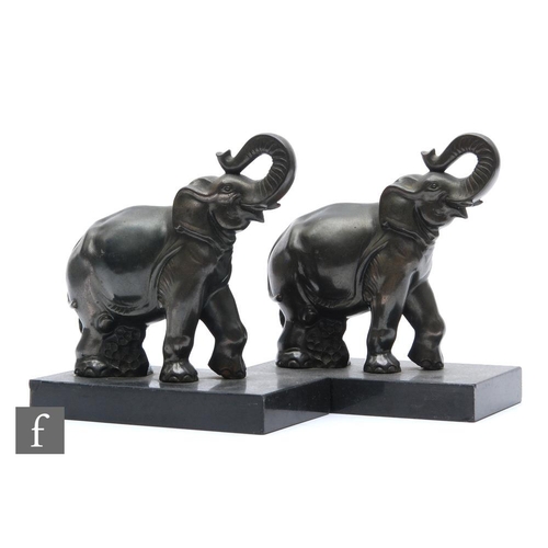 909 - A pair of 20th Century spelter bookends decorated with stylised elephants mounted to a rectangular b... 