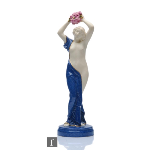 61 - A 1920s Art Deco Royal Worcester Crown Ware figurine modelled as a scantily clad female holding alof... 