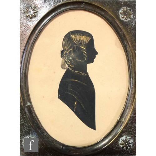 575 - An early 19th Century painted silhouette portrait depicting a lady sitting at a table, in maple wood... 