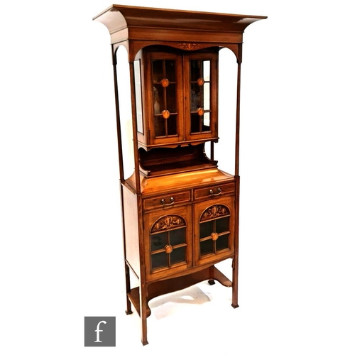 1138 - An Art Nouveau mahogany salon display cabinet, with cornice pediment over turned pillar supports a g... 