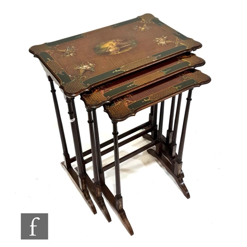 1150 - A nest of three early 20th Century mahogany occasional tables, decorated with floral panels within t... 