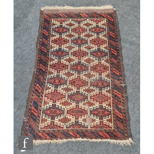 1133 - An early 20th Century Bokhara rug, decorated with repeat pattern hooked medallions of red, blue and ... 