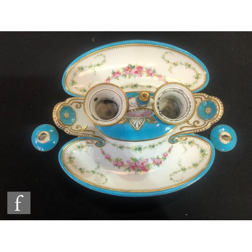 75 - A 19th Century Minton desk stand with twin inkwells flanking a pink medallion, raised to a shaped di... 