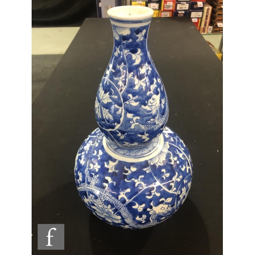 168 - A Chinese blue and white double-gourd vase, the body with a rich cobalt ground, picked out with drag... 