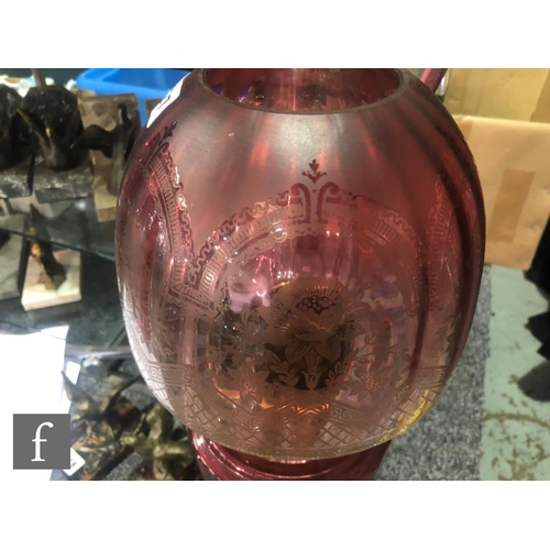 327 - A late 19th Century oil lamp, the brass spreading circular base supporting a faceted cranberry glass... 