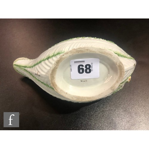 68 - An 18th Century Worcester Cos Lettuce shape sauce boat, the moulded body sparsely decorated with han... 