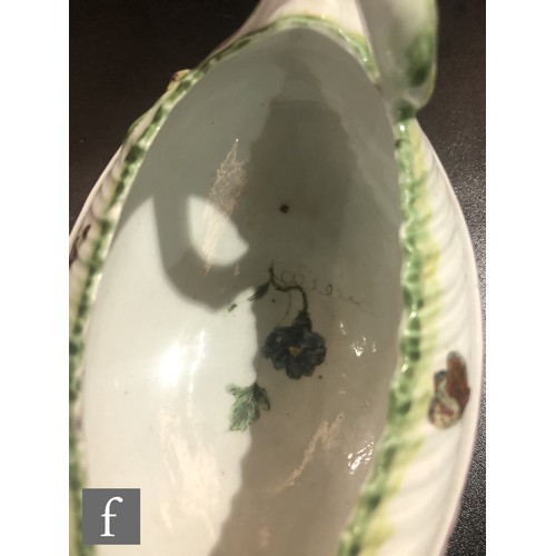 68 - An 18th Century Worcester Cos Lettuce shape sauce boat, the moulded body sparsely decorated with han... 