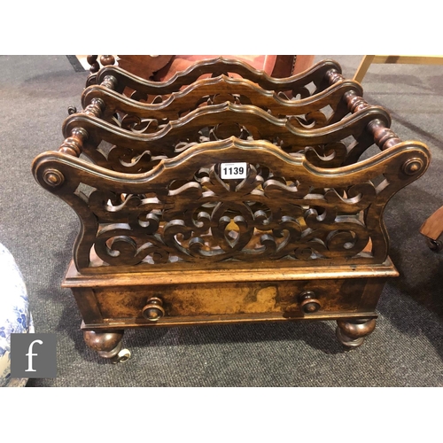 1139 - A Victorian walnut three-division Canterbury, with fret-cut divisions over a single frieze drawer, h... 